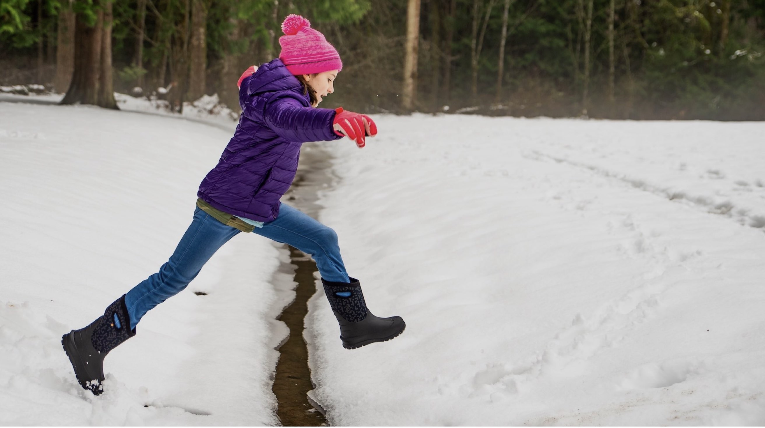 Image features the kids neo-classic boot jumping in the snow.