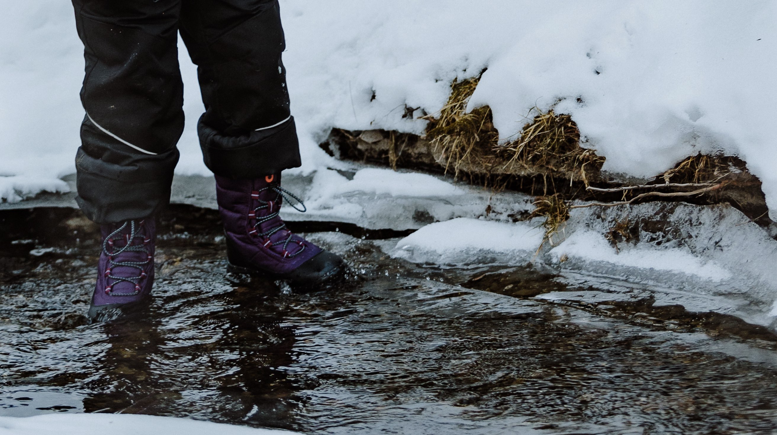 Image features the kids Skyline Snowcata boot in a creek.