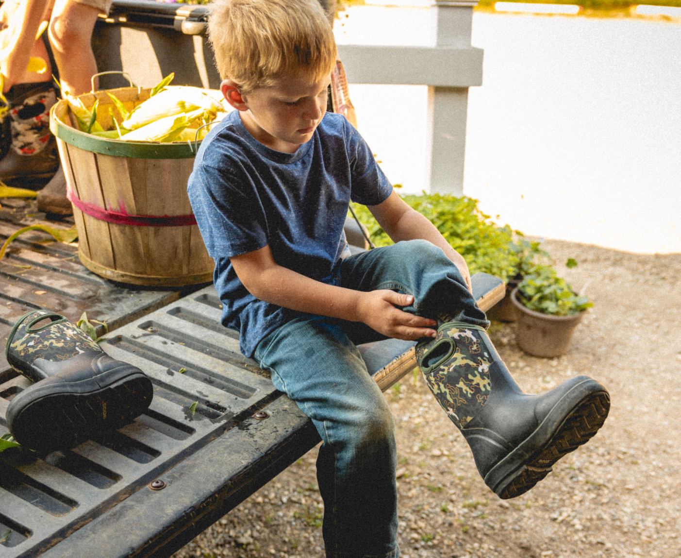 Shop our Kids' Seamless boots.  The image shown is a kid pulling on his Neo-Classic boots on the back of a pick-up truck