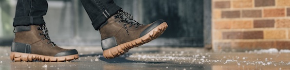 Image shown is our Men's Arcata Urban Leather Mid in brown in a icy street backdrop.