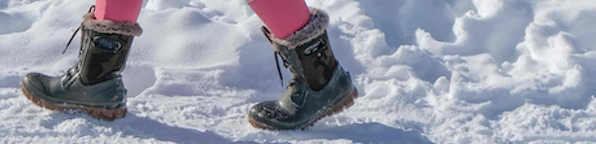 Image shown is a close-up of our Women's Arcata Camo winter boots in a green camo.  The backdrop is wintery snow trail.